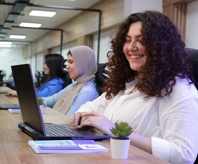 why FlairsTech a professional smiling while working on a laptop
